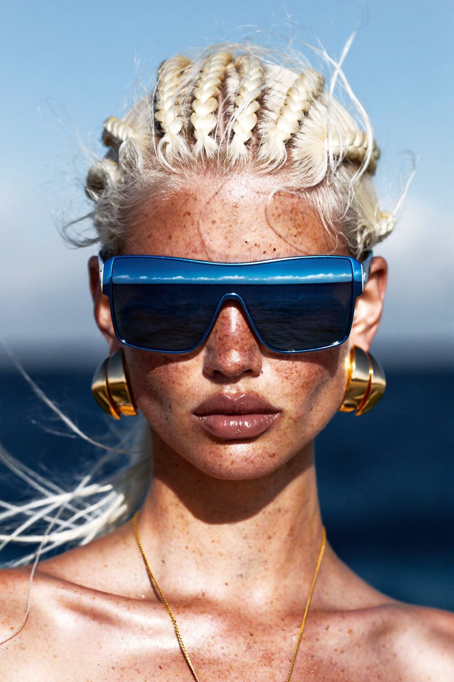 A woman with braids and blue sunglasses